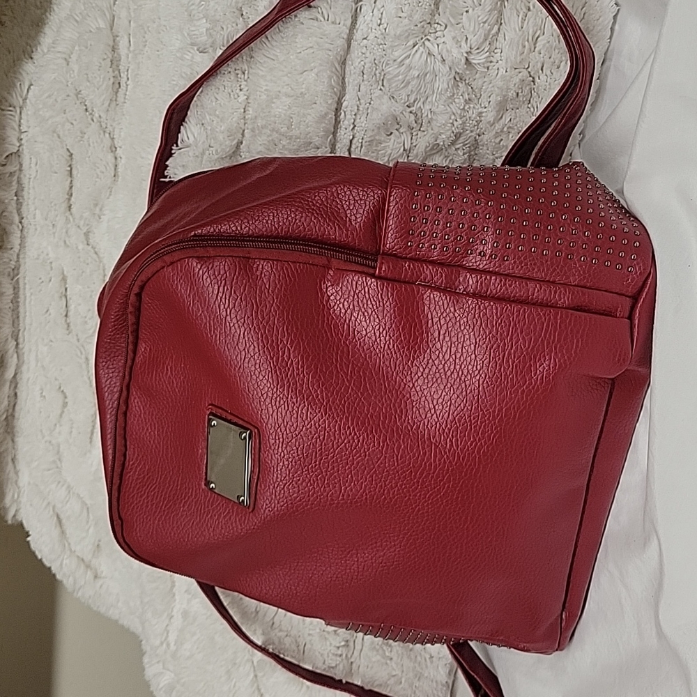 Light leatherette red backpack with studded side pockets on each side.